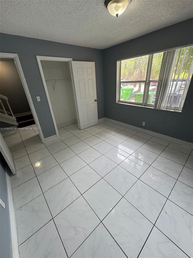 5955 NW 25th Ct Unit 208, Sunrise, FL 33313 - unfurnished bedroom with multiple windows, a closet, and a textured ceiling