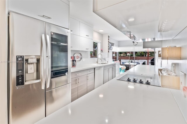 1000 NE 204th Ln, Miami, FL 33179 - kitchen with white cabinets, black electric cooktop, light countertops, a sink, and stainless steel refrigerator with ice dispenser