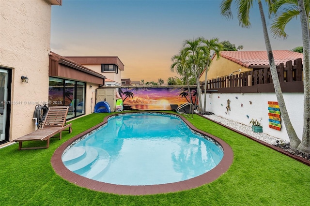 1000 NE 204th Ln, Miami, FL 33179 - pool at dusk featuring a lawn, fence, and a fenced in pool