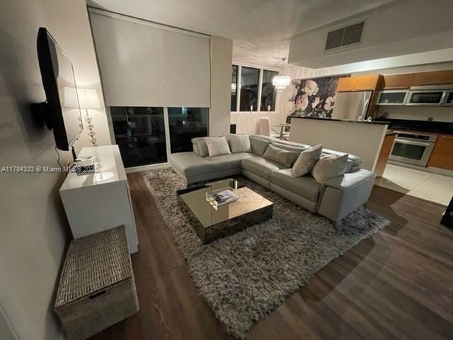 living room featuring light wood-style floors and visible vents