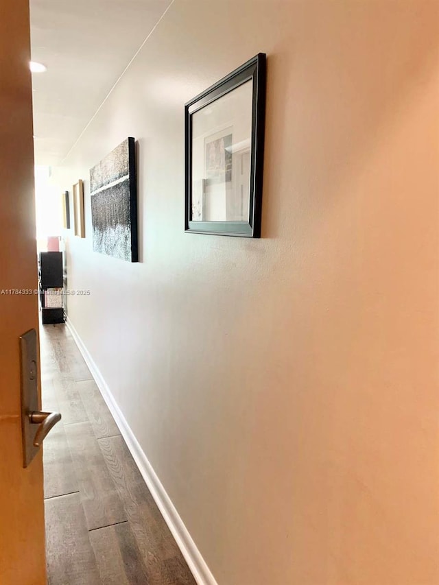 hallway with wood finished floors and baseboards