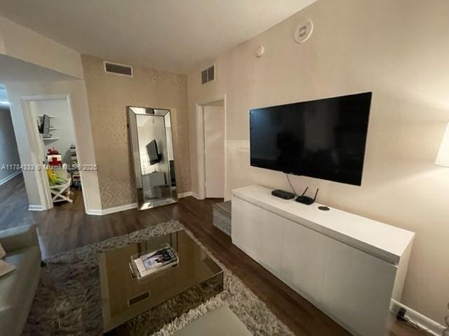 living room featuring visible vents and dark wood-style flooring
