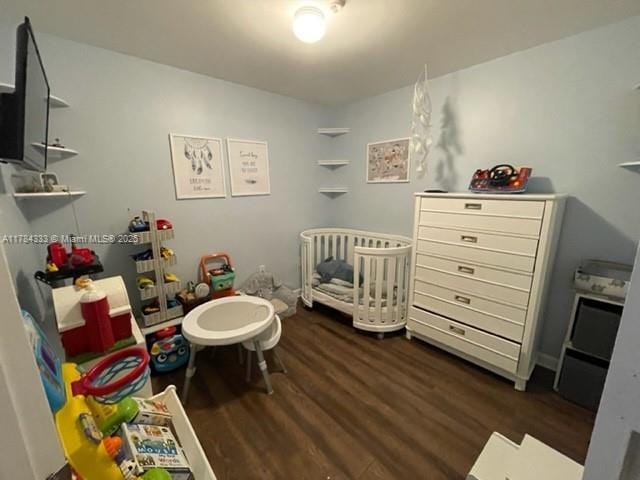 bedroom featuring a crib and wood finished floors
