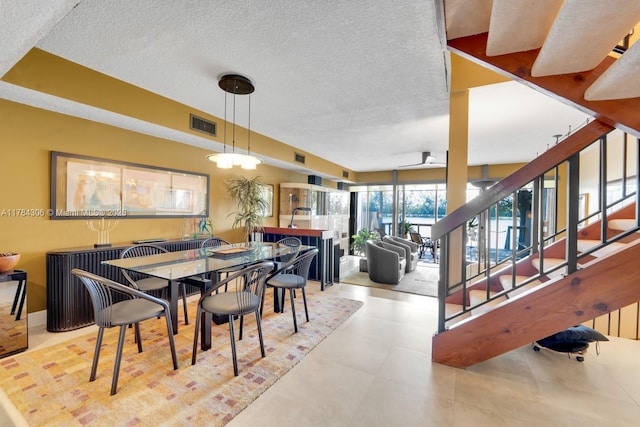 dining space featuring a textured ceiling, visible vents, and stairs