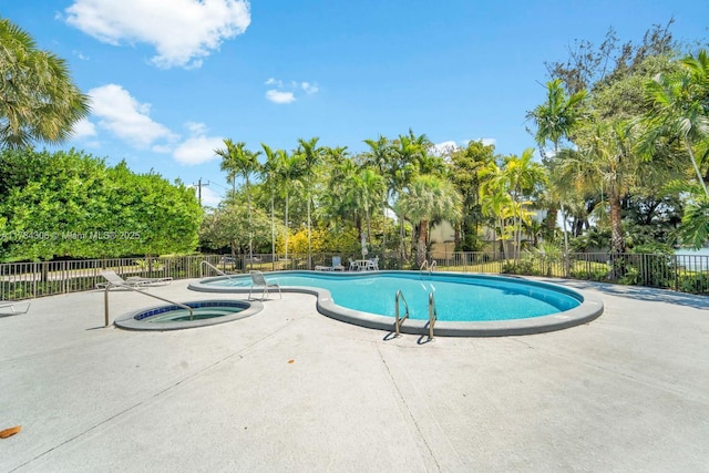 community pool featuring a patio area, fence, and a community hot tub