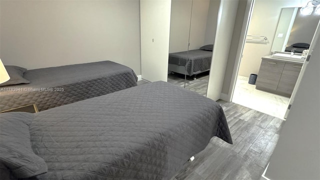 400 SE Sunny Isles Blvd Unit 1702, Sunny Isles Beach, FL 33160 - bedroom with light wood-style floors, baseboards, a closet, and a sink