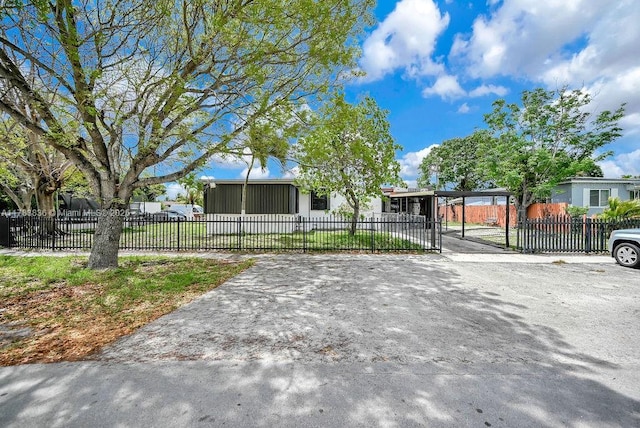 5080 E 5th Ave, Hialeah, FL 33013 - view of front facade featuring a carport, a fenced front yard, and driveway