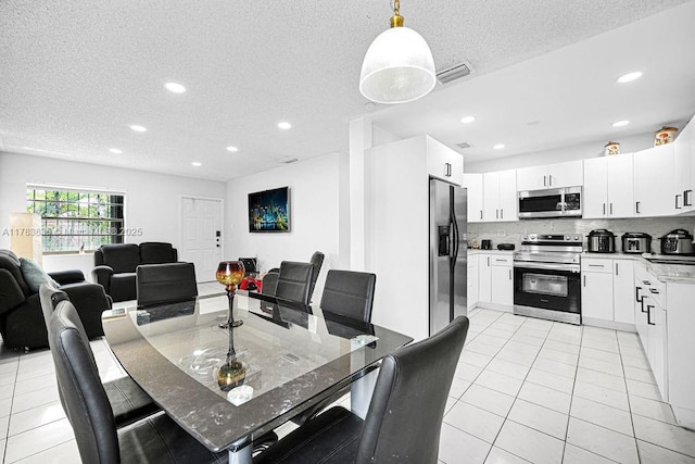 5080 E 5th Ave, Hialeah, FL 33013 - dining area with light tile patterned floors, a textured ceiling, and recessed lighting
