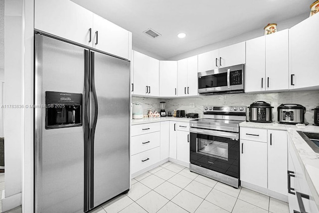 5080 E 5th Ave, Hialeah, FL 33013 - kitchen featuring appliances with stainless steel finishes, white cabinets, backsplash, light tile patterned floors, and recessed lighting
