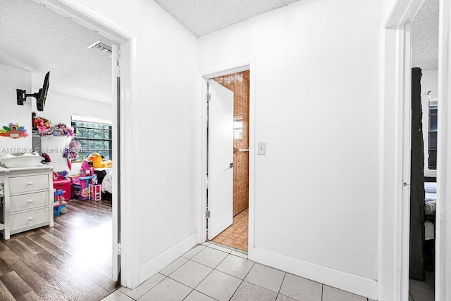 5080 E 5th Ave, Hialeah, FL 33013 - hallway featuring a textured ceiling and light tile patterned floors