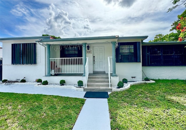 5080 E 5th Ave, Hialeah, FL 33013 - view of front of home with a front yard, covered porch, and stucco siding