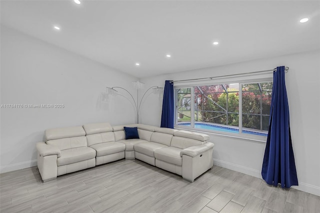 living area featuring light wood-type flooring, baseboards, and recessed lighting