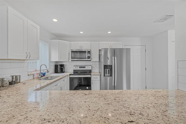 kitchen featuring light stone counters, recessed lighting, white cabinets, visible vents, and stainless steel appliances