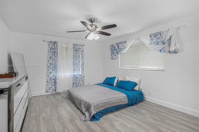 bedroom featuring baseboards, wood tiled floor, and a ceiling fan