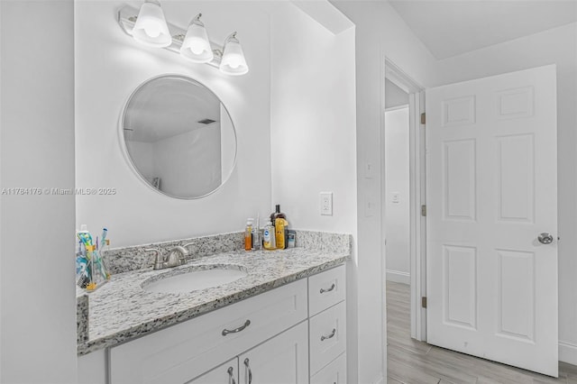 bathroom with wood finished floors, vanity, and baseboards
