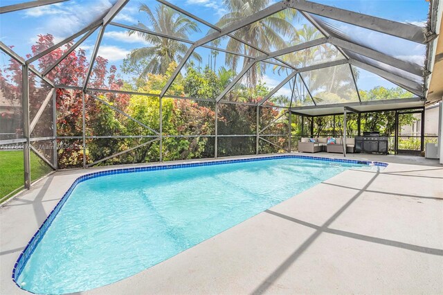 outdoor pool with a patio area, outdoor lounge area, and a lanai