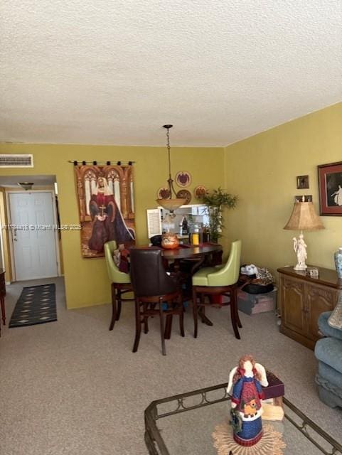carpeted dining space featuring visible vents and a textured ceiling