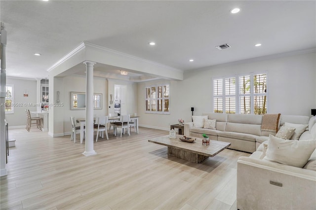 living area with baseboards, crown molding, visible vents, a healthy amount of sunlight, and decorative columns