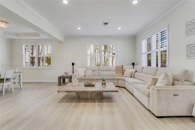 living room with crown molding, light wood-style floors, and a wealth of natural light