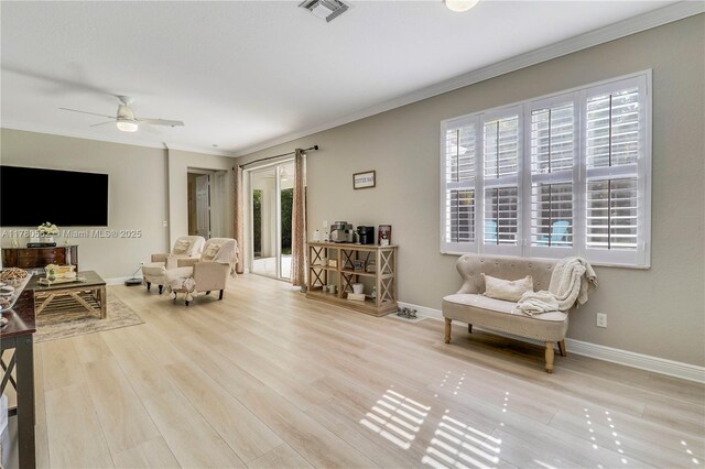 living area with visible vents, baseboards, ceiling fan, crown molding, and wood finished floors
