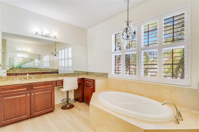 full bathroom featuring a bath, vanity, and a notable chandelier