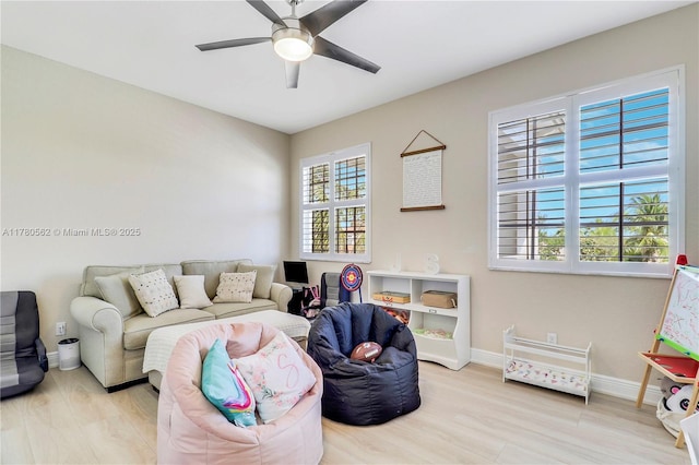 living area with wood finished floors, ceiling fan, and baseboards