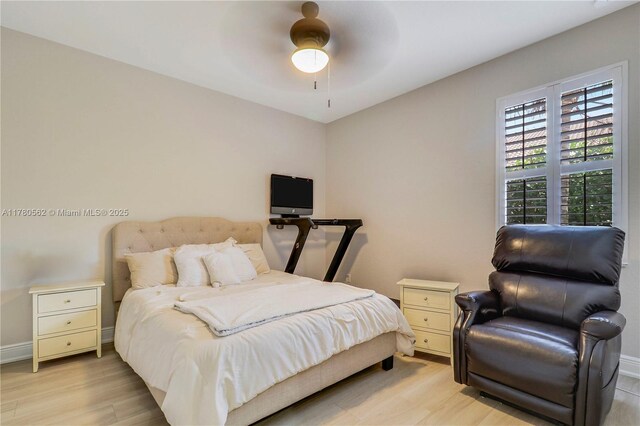 bedroom featuring light wood-style flooring, a ceiling fan, and baseboards