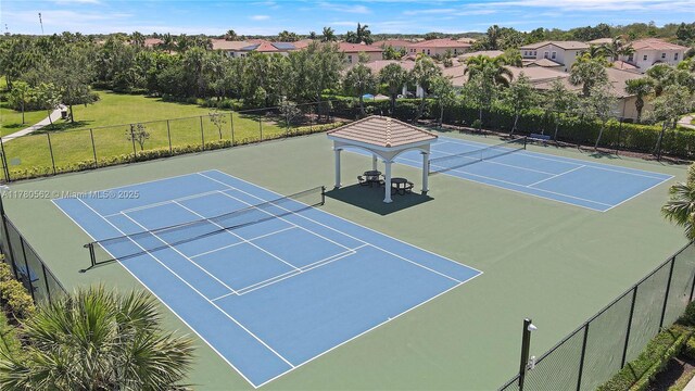 view of sport court with a residential view and fence