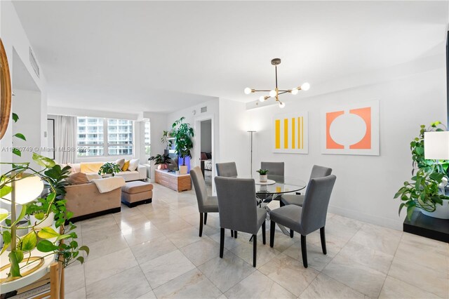 1500 Bay Rd Unit 668S, Miami Beach, FL 33139 - dining room featuring visible vents, marble finish floor, baseboards, and a notable chandelier