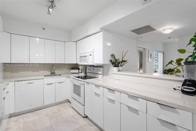 1500 Bay Rd Unit 668S, Miami Beach, FL 33139 - kitchen with white cabinets, a sink, and white appliances