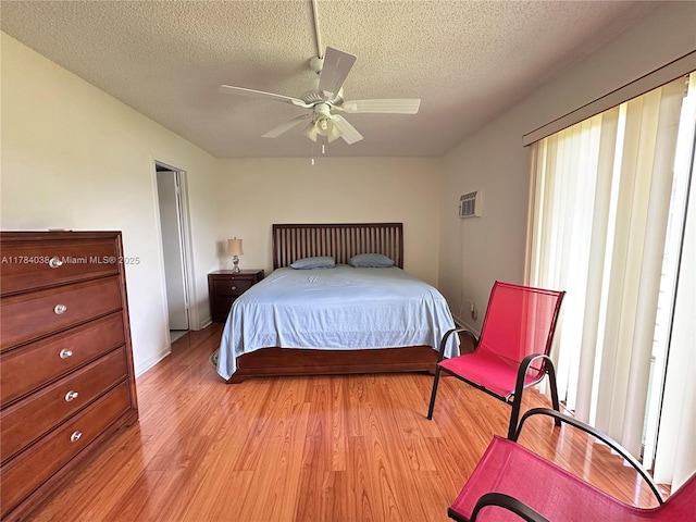 569 N Fanshaw N Unit 569, Boca Raton, FL 33434 - bedroom with light wood-style flooring, a textured ceiling, a ceiling fan, and a wall unit AC