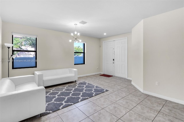 entrance foyer with baseboards, light tile patterned floors, a notable chandelier, and plenty of natural light