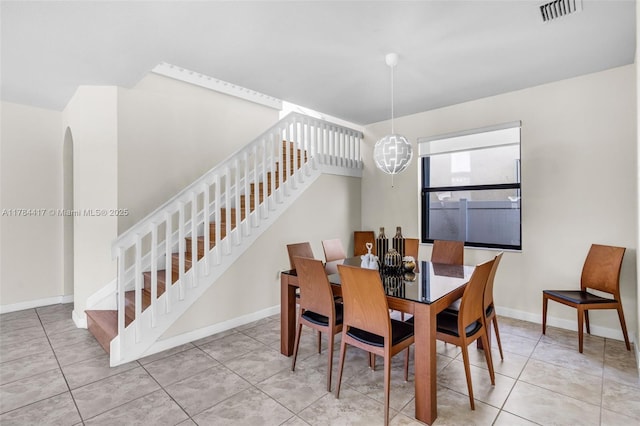 tiled dining area with a chandelier, stairs, visible vents, and baseboards