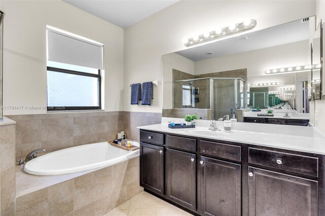 bathroom featuring vanity, tile patterned flooring, a stall shower, and a garden tub