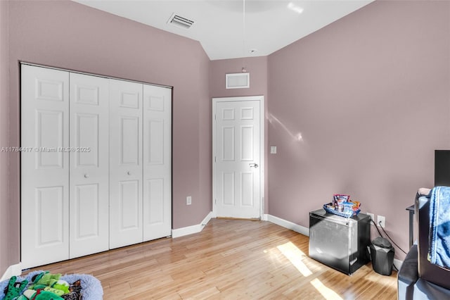 interior space with light wood-style floors, a closet, baseboards, and visible vents