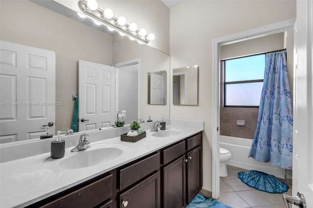 bathroom with toilet, tile patterned floors, double vanity, and a sink