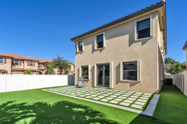 back of property with cooling unit, a patio, stucco siding, and a lawn