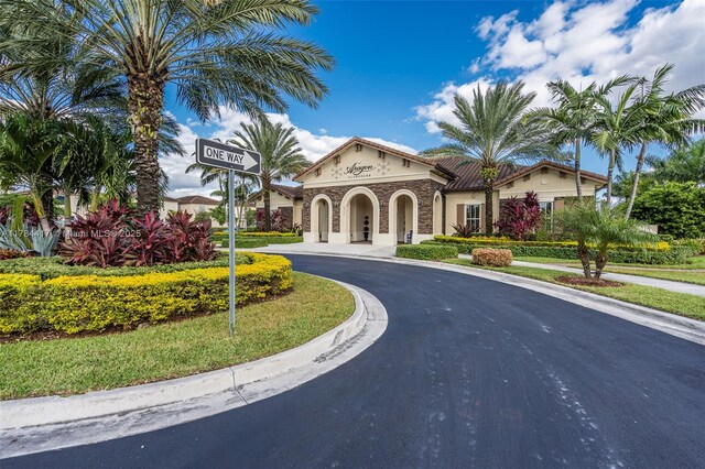 exterior space featuring curved driveway, stucco siding, and a tiled roof