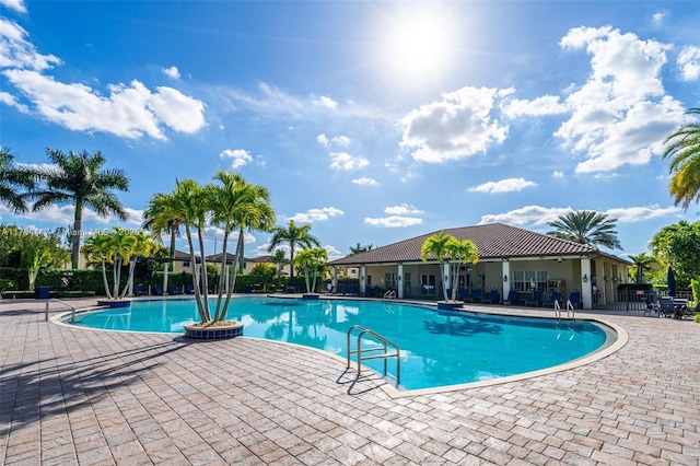 community pool featuring a patio and fence