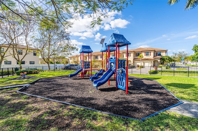 community jungle gym featuring a yard, fence, and a residential view