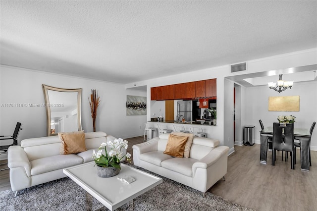 1200 Brickell Bay Dr Unit 1723, Miami, FL 33131 - living area with light wood-style flooring, a textured ceiling, a chandelier, and visible vents