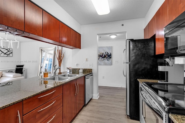 1200 Brickell Bay Dr Unit 1723, Miami, FL 33131 - kitchen with baseboards, a textured ceiling, light wood-style floors, stainless steel appliances, and a sink