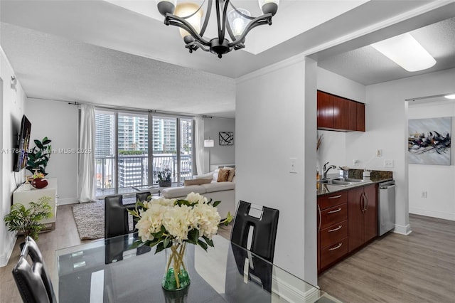 1200 Brickell Bay Dr Unit 1723, Miami, FL 33131 - dining area with a chandelier, a textured ceiling, light wood finished floors, and baseboards