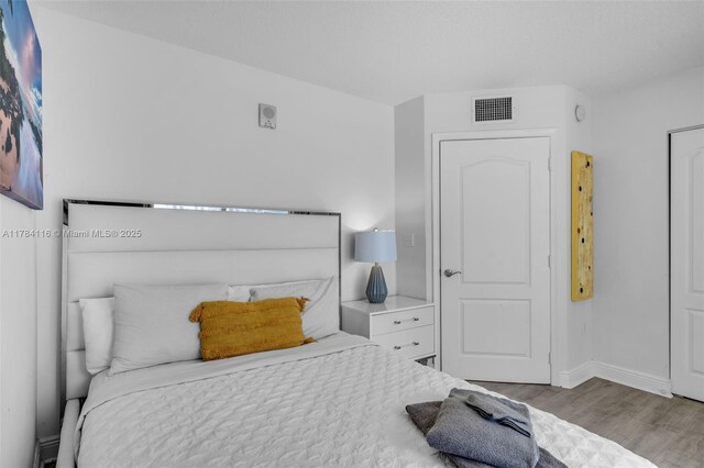 1200 Brickell Bay Dr Unit 1723, Miami, FL 33131 - bedroom with wood finished floors, baseboards, and visible vents