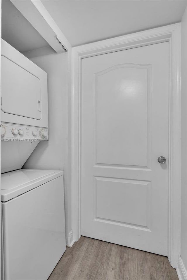 1200 Brickell Bay Dr Unit 1723, Miami, FL 33131 - clothes washing area featuring light wood-style floors, laundry area, and stacked washer and clothes dryer