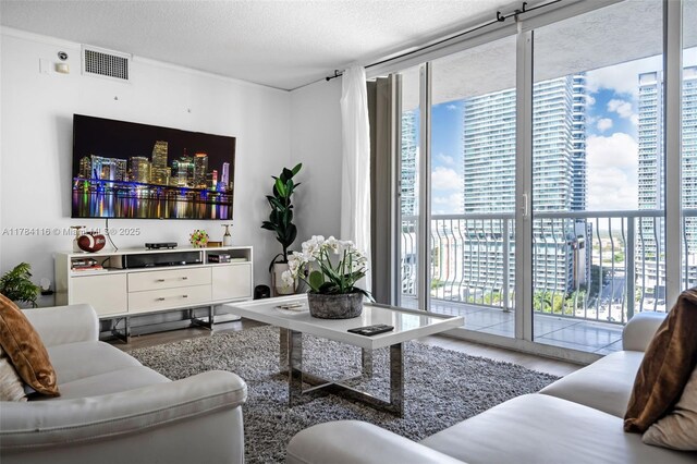1200 Brickell Bay Dr Unit 1723, Miami, FL 33131 - living room with a city view, expansive windows, a textured ceiling, visible vents, and wood finished floors