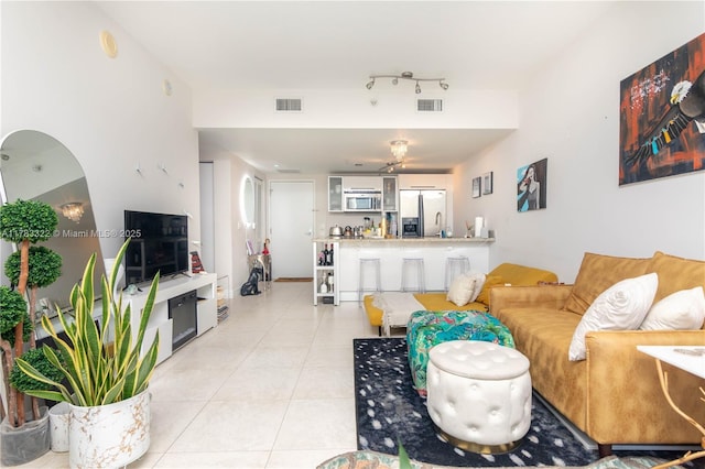 living room with light tile patterned floors and visible vents