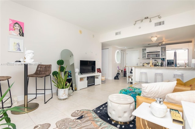 living room with light tile patterned floors and visible vents