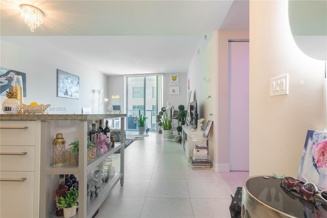 hall with floor to ceiling windows and light tile patterned floors