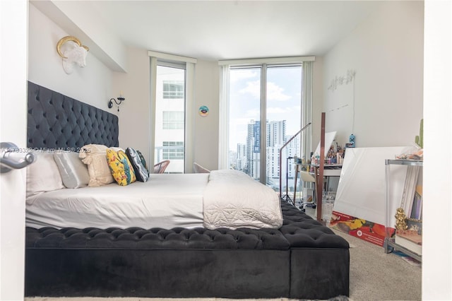 carpeted bedroom featuring a view of city, access to outside, and multiple windows